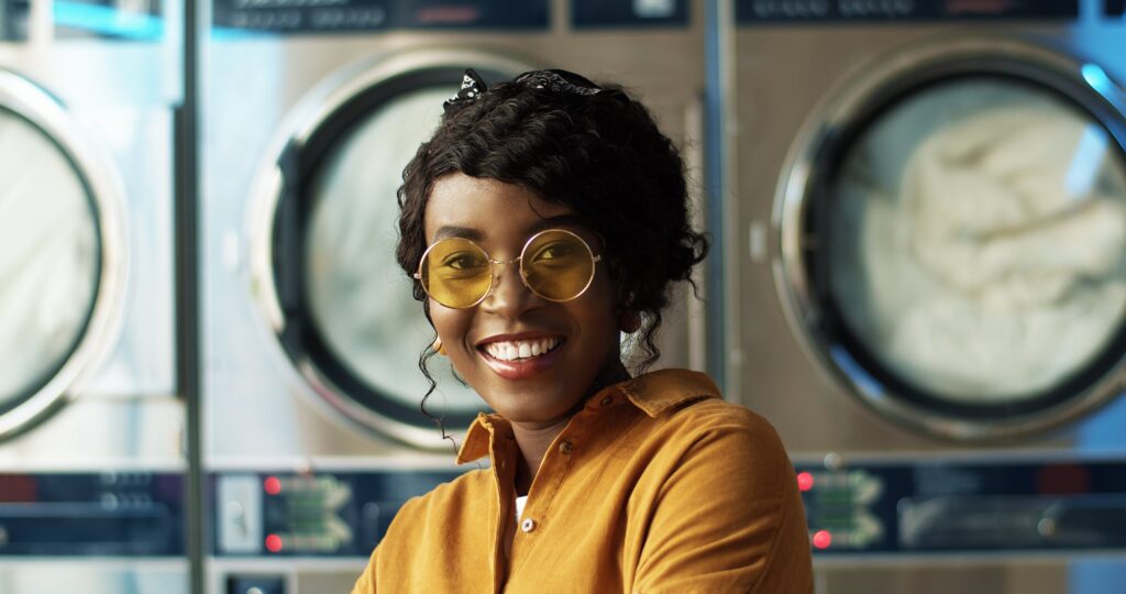 Smiling young woman at the laundromat