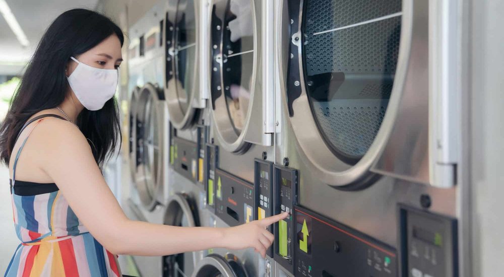 Woman-operating-Laundry-Machine Woman-operating-Laundry-Machine